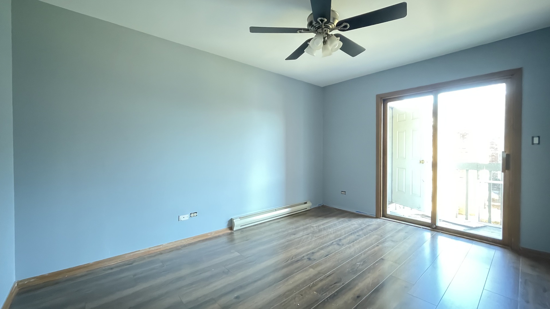 4301 West Shamrock Lane, Unit 2D McHenry, IL 60050 - Photo 7 of 18 an empty room with wooden floor fan and windows