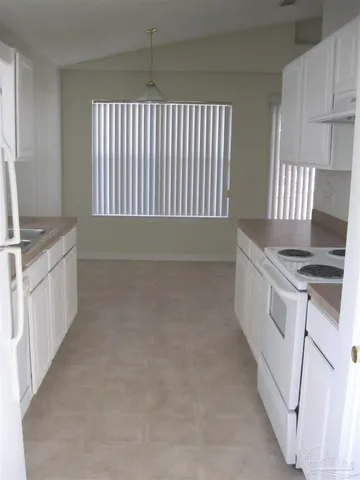 a kitchen with granite countertop white cabinets and white appliances