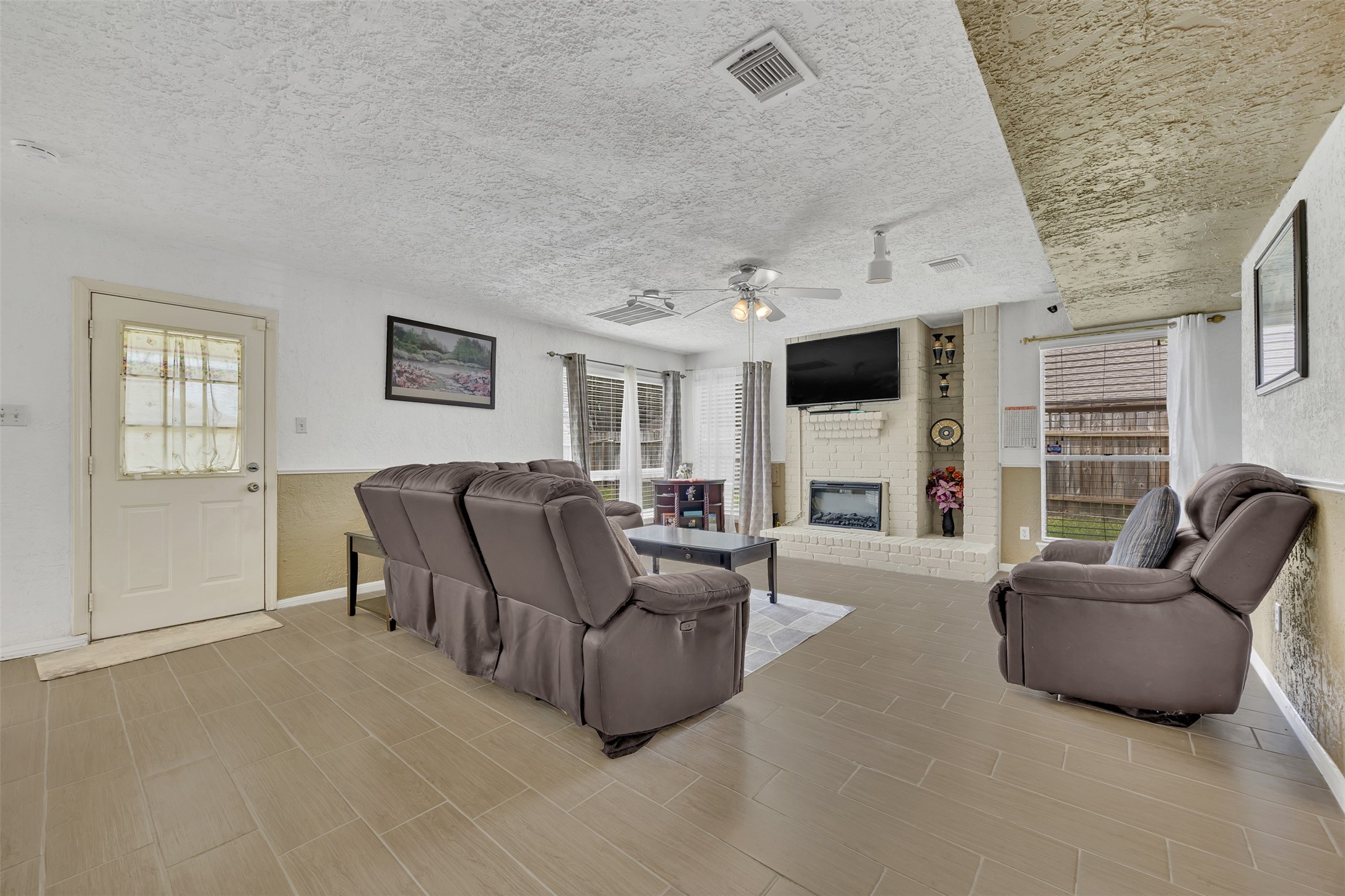 15619 Beechnut Street Houston, TX 77083 - Photo 9 of 29 Cozy second living area with a fireplace and backyard access — a great spot to relax or unwind.