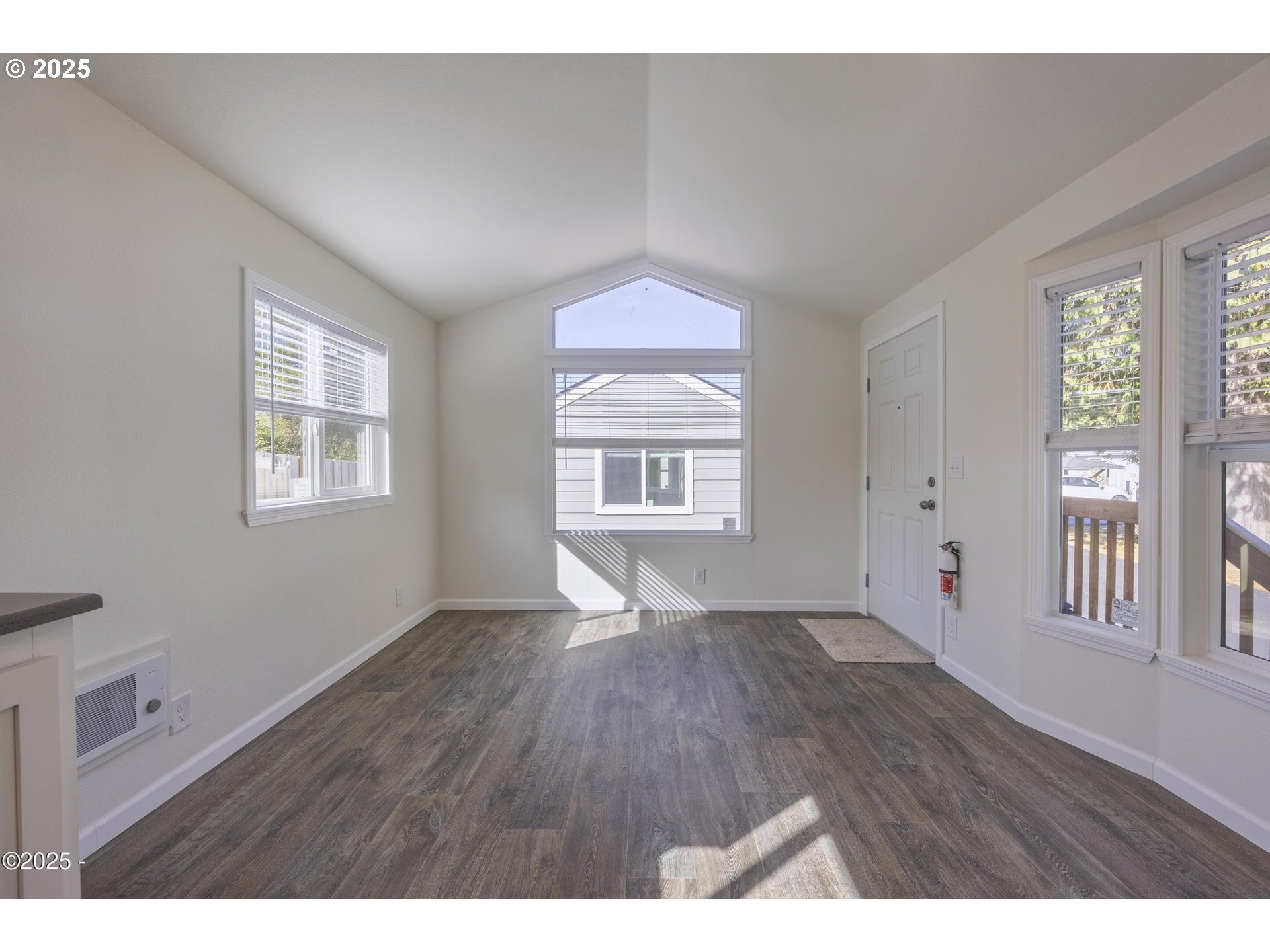 4875 Highway 101, Unit 96 Depoe Bay, OR 97341 - Photo 4 of 18 a view of an empty room with wooden floor and a window