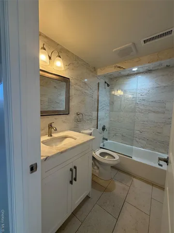 a bathroom with a granite countertop sink a toilet and shower