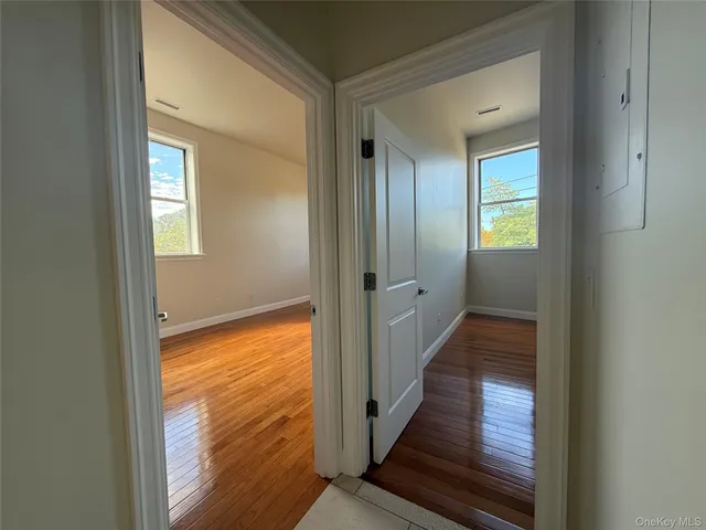 a view of a room with wooden floor and a bathroom