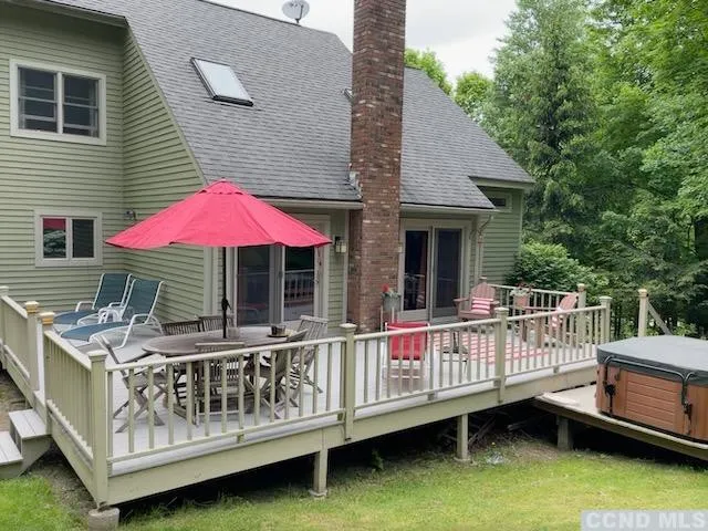 a view of a house with a wooden deck and furniture