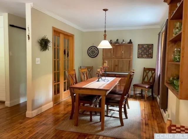 a view of a dining room and livingroom with furniture wooden floor a chandelier