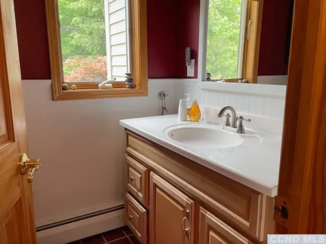 a bathroom with a sink a window and a mirror