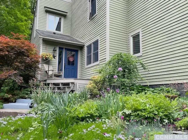 a view of a house with potted plants and a table and chairs