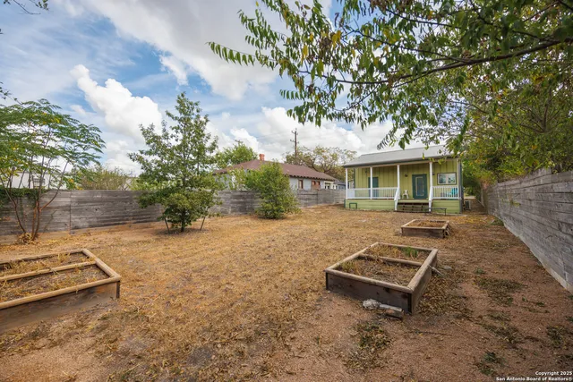 a view of a house with a large window and wooden fence
