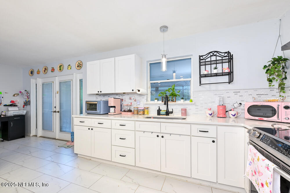 6408 Diane Road Jacksonville, FL 32277 - Photo 11 of 30 a kitchen with granite countertop a sink and a stove top oven