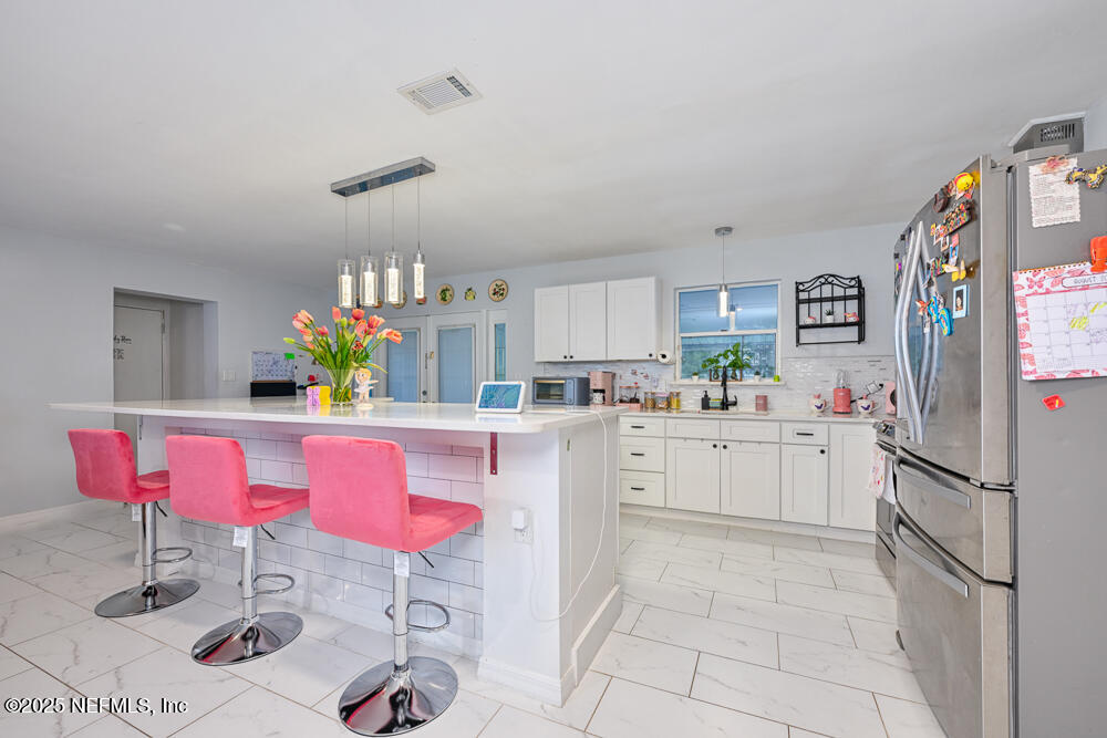 6408 Diane Road Jacksonville, FL 32277 - Photo 13 of 30 a kitchen with a dining table cabinets and stainless steel appliances