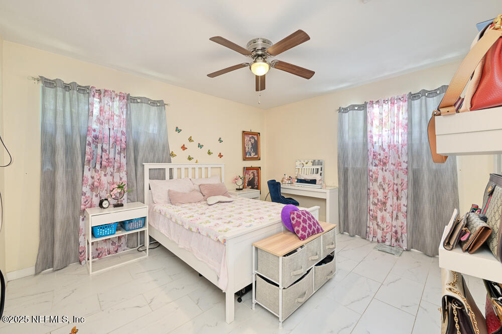 6408 Diane Road Jacksonville, FL 32277 - Photo 16 of 30 a bedroom with a bed and a chandelier