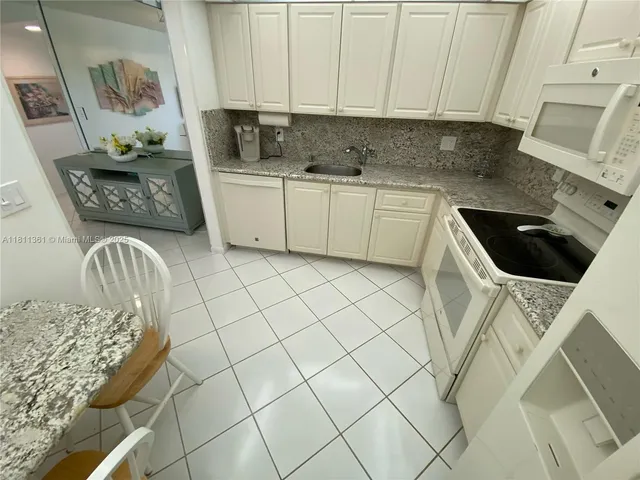a kitchen with a sink a stove and cabinets