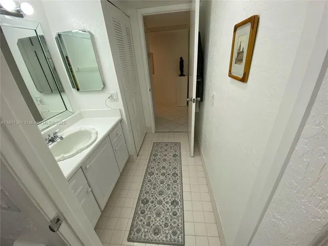 a bathroom with a sink and mirror with bathtub