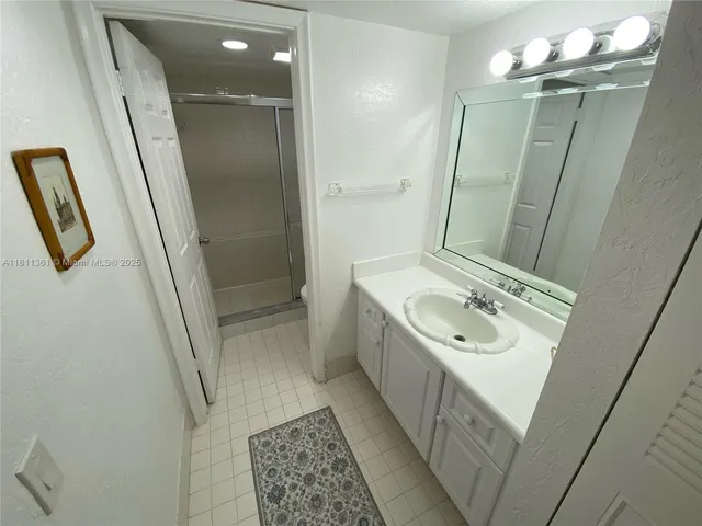 a bathroom with a sink a toilet a mirror and shower