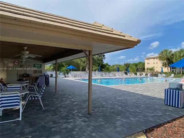 a view of a patio with a table and chairs under an umbrella
