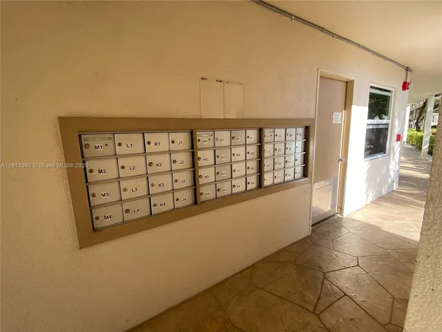 a view of a hallway with wooden floor and natural light