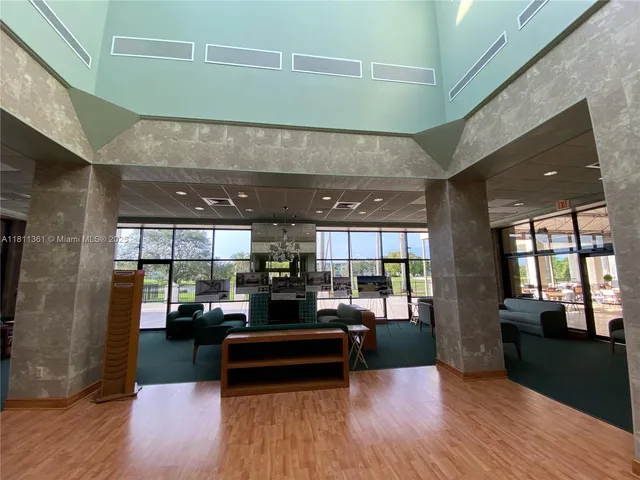 a living room with stainless steel appliances kitchen island granite countertop lots of wooden furniture and a large window