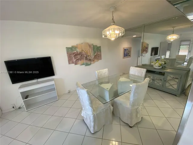 a living room with couches a computer and a table with wooden floor