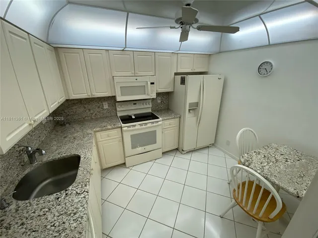 a kitchen with stainless steel appliances granite countertop a sink a stove a refrigerator and cabinets