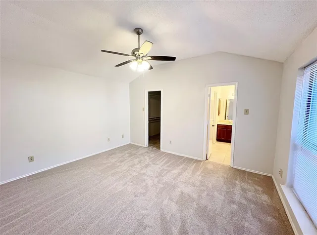 an empty room with closet and a ceiling fan