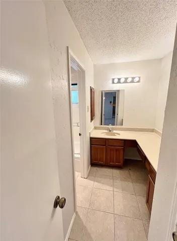 a view of a hallway with wooden floor and a bathroom