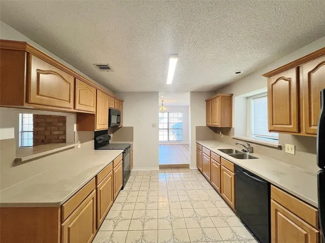 a kitchen with a sink stove top oven and refrigerator