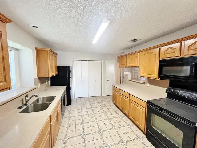 a kitchen with a stove a refrigerator and a sink