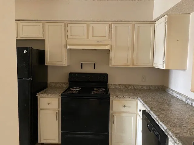 a kitchen with granite countertop a stove and a white refrigerator