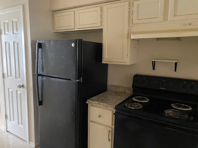 a kitchen with a refrigerator stove and cabinets