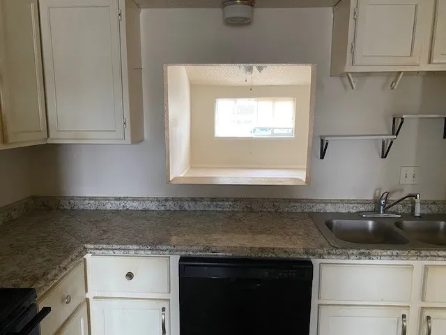 a kitchen with a sink cabinets and window