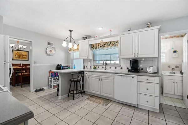 a kitchen with cabinets and chairs