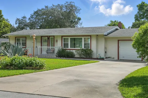 a front view of a house with a garden and plants