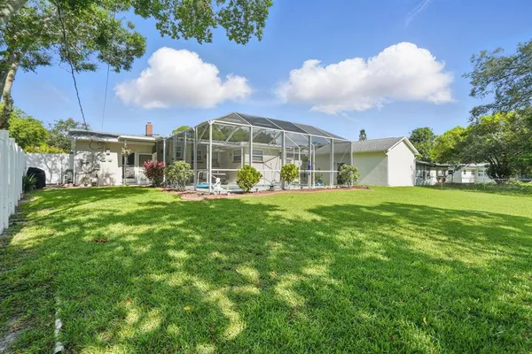 a view of a house with a big yard and large trees