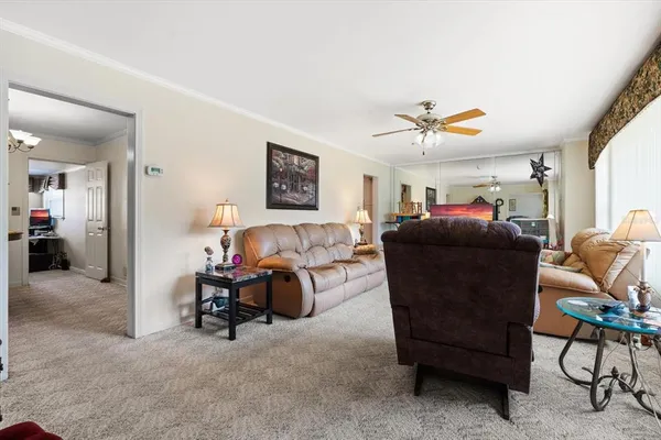 a living room with furniture a ceiling fan and a window