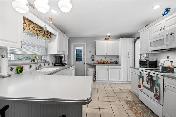 a kitchen with stainless steel appliances a white stove top oven a sink a counter space and cabinets