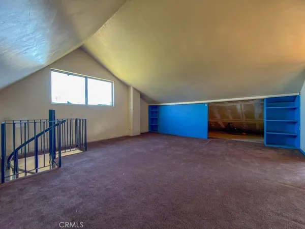 an empty room with a fireplace and entryway