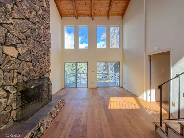 a view of a hallway with wooden floor and closet