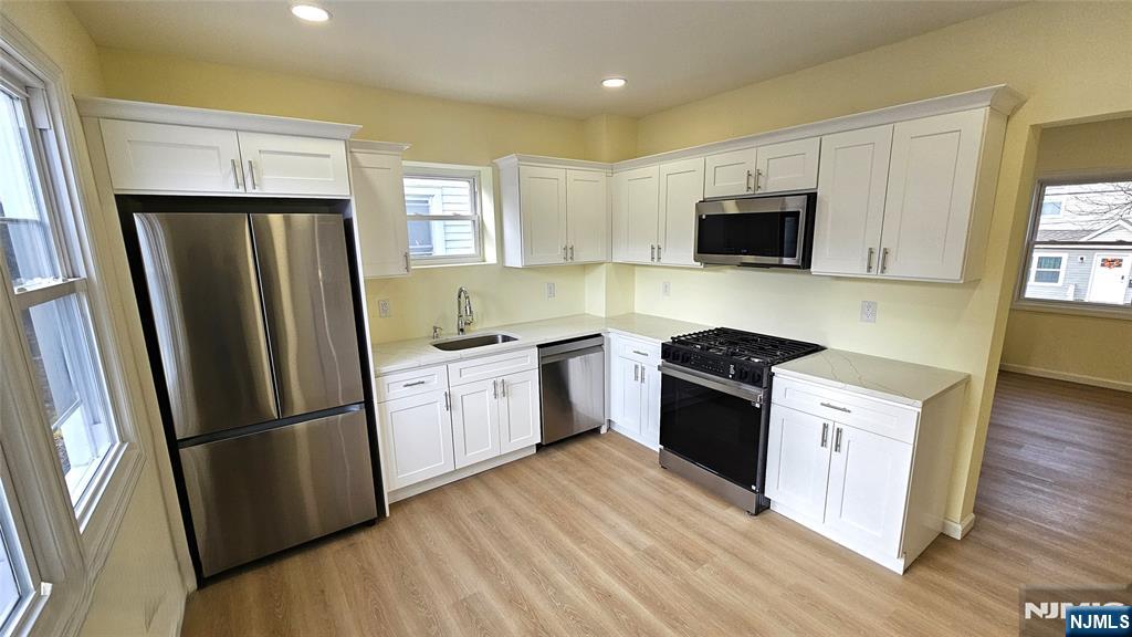 8 Tiffany Boulevard Newark, NJ 07104 - Photo 8 of 16 a kitchen with a refrigerator stove and wooden cabinets