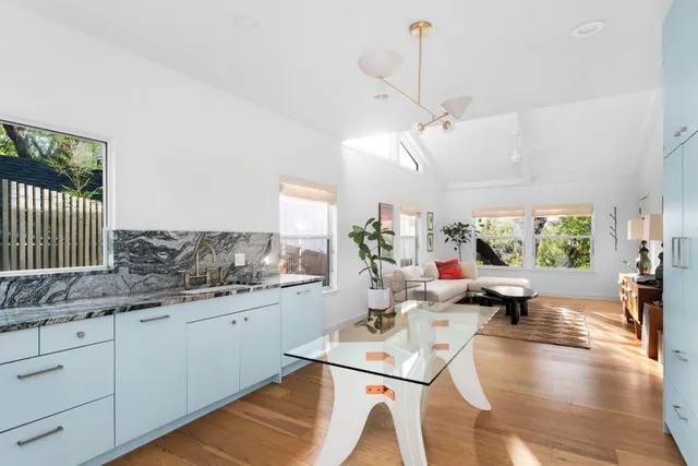 a living room with kitchen island granite countertop furniture a rug a sink and a large window