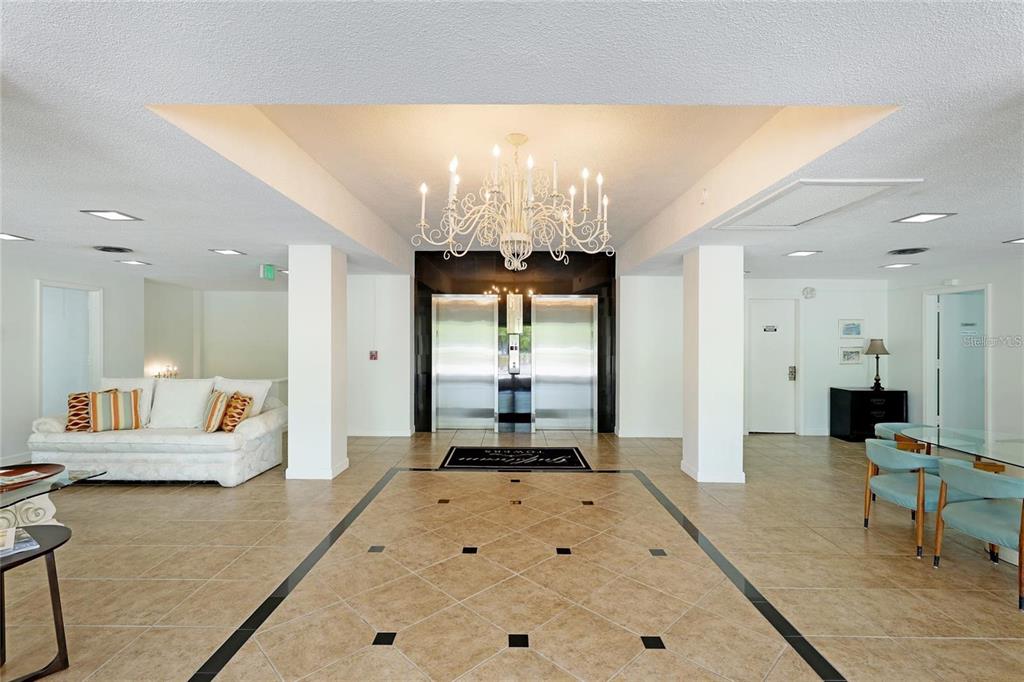 33 South Gulfstream Avenue, Unit 307 Sarasota, FL 34236 - Photo 3 of 34 a living room with furniture and a chandelier