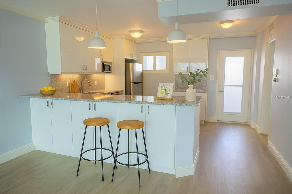 33 South Gulfstream Avenue, Unit 307 Sarasota, FL 34236 - Photo 10 of 34 a kitchen with stainless steel appliances kitchen island granite countertop a table and chairs