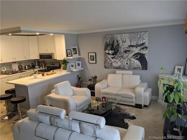 a living room with furniture and a potted plant on a dresser