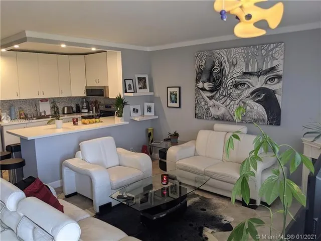 a living room with furniture and painting on the wall