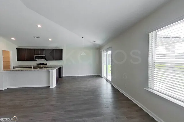 a view of kitchen with microwave oven stove and white cabinets with wooden floor