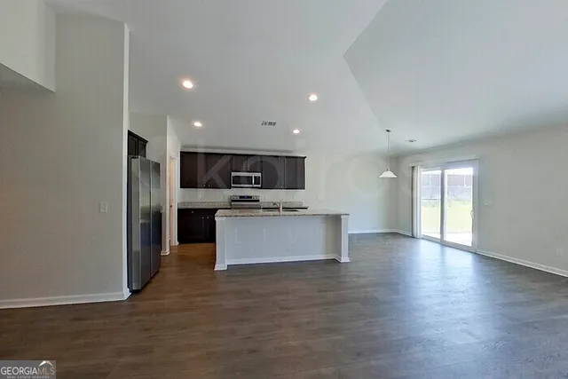 a large kitchen with stainless steel appliances a large counter top and a stove