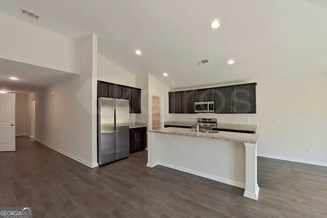 a kitchen with stainless steel appliances a refrigerator and a stove top oven