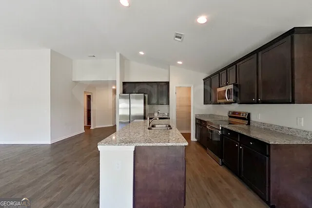 a large kitchen with stainless steel appliances lots of counter top space cabinets and a center island