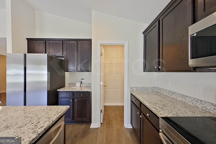 100 Ebenezer Blf Way Springfield, GA 31329 - Photo 7 of 20 a kitchen with granite countertop a oven a refrigerator and wooden floor