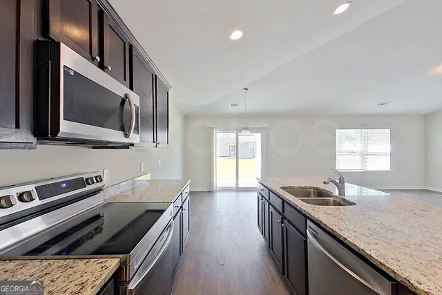 a kitchen with stainless steel appliances granite countertop a sink and stove
