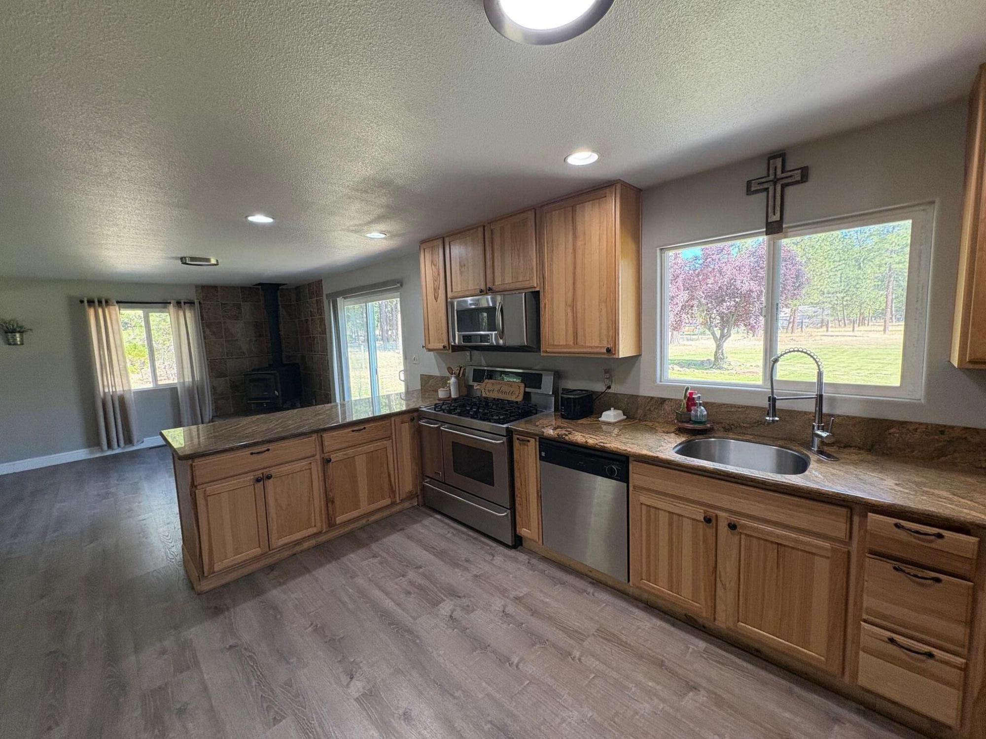 40596 Old School Road Fall River Mills, CA 96028 - Photo 15 of 29 a kitchen with granite countertop wooden floors a sink and appliances