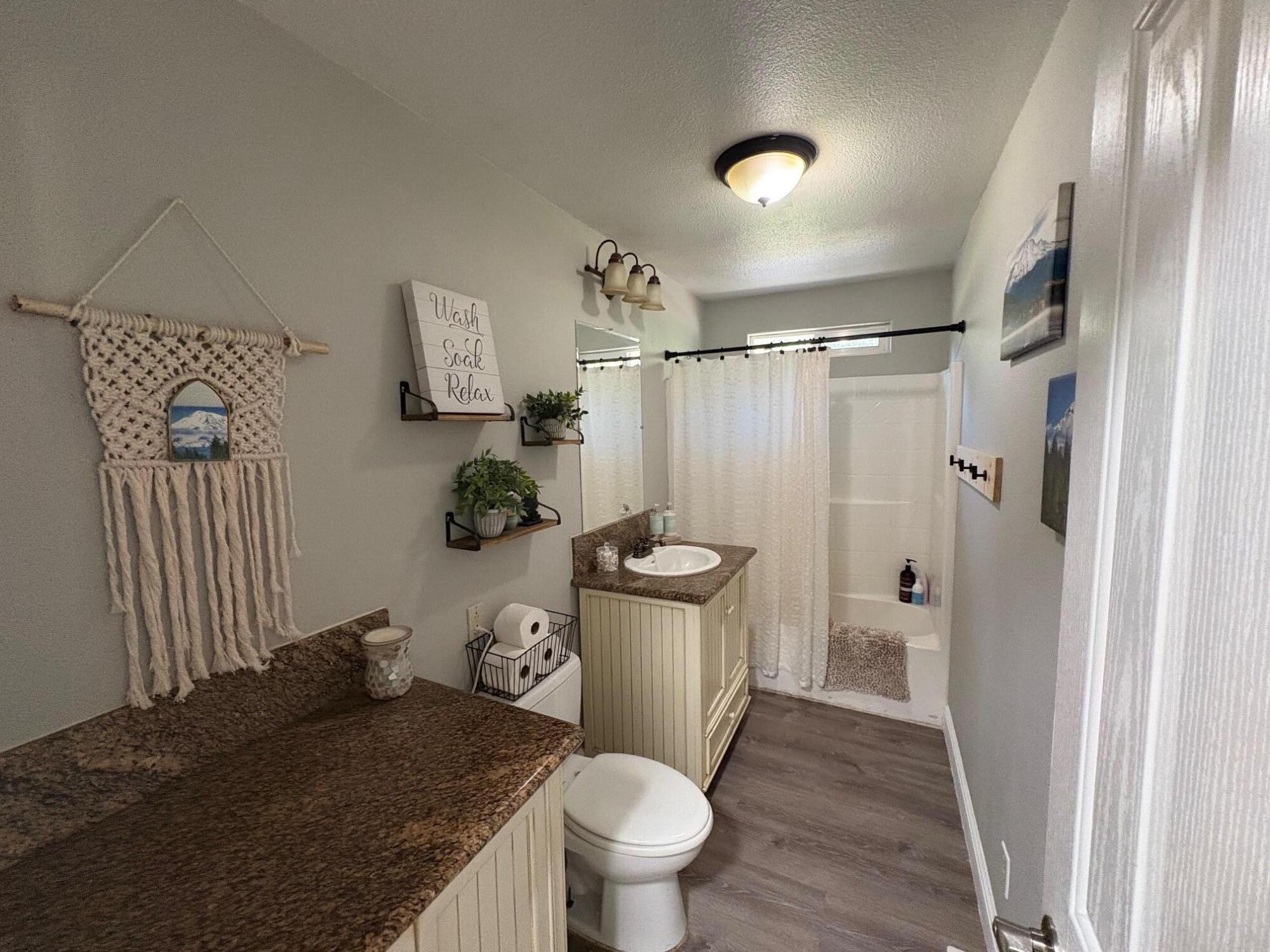 40596 Old School Road Fall River Mills, CA 96028 - Photo 17 of 29 a bathroom with a granite countertop toilet a sink and a mirror